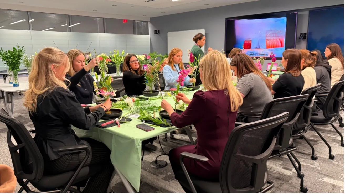 Corporate team members creating Ikebana arrangements together during an on-site workshop in Northern Virginia